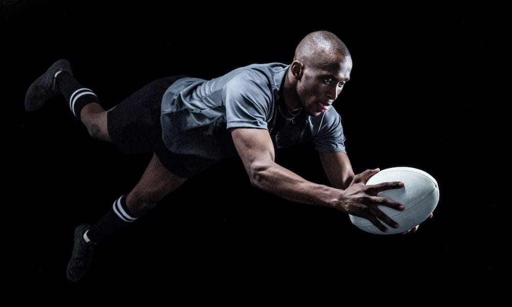 Sportsman jumping for catching rugby ball over black background Rugby decision misleading, researcher claims