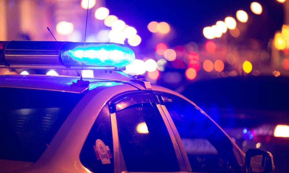 Blue light flasher atop of a police car. City lights on the background. Blues & Tunes music therapy pilot hailed a success