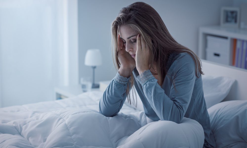 Depressed woman awake in the night, she is exhausted and suffering from insomnia The impact of stress on sleep