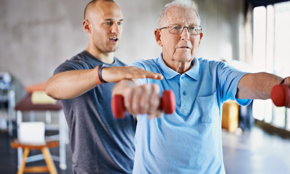 Rehabilitation is never easy. Shot of a physiotherapist helping a senior man with weights. ‘I decided that I had Parkinson’s but Parkinson’s didn’t have me’