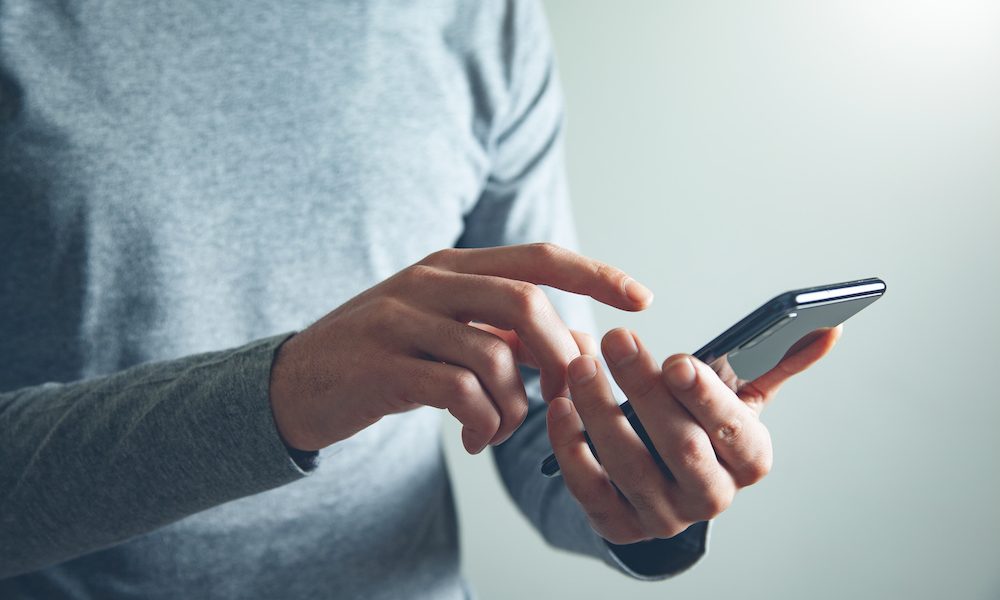 man hand holding smart phone App improves depression symptoms among primary care patients