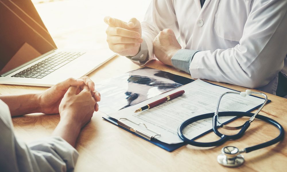 Doctors and patients sit and talk to the patient about medication. At the table near the window in the hospital. ‘Level inequality in dementia diagnosis rates’