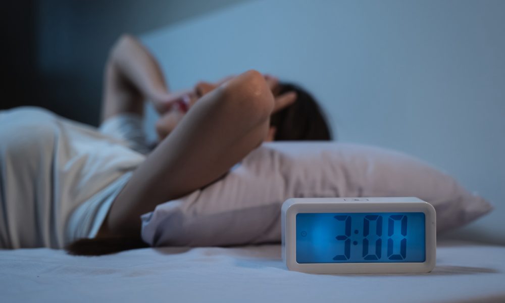woman have insomnia on the bed selective focus on alarm clock at three in the morning. Poor sleep linked to symptoms of muscle dysmorphia – study