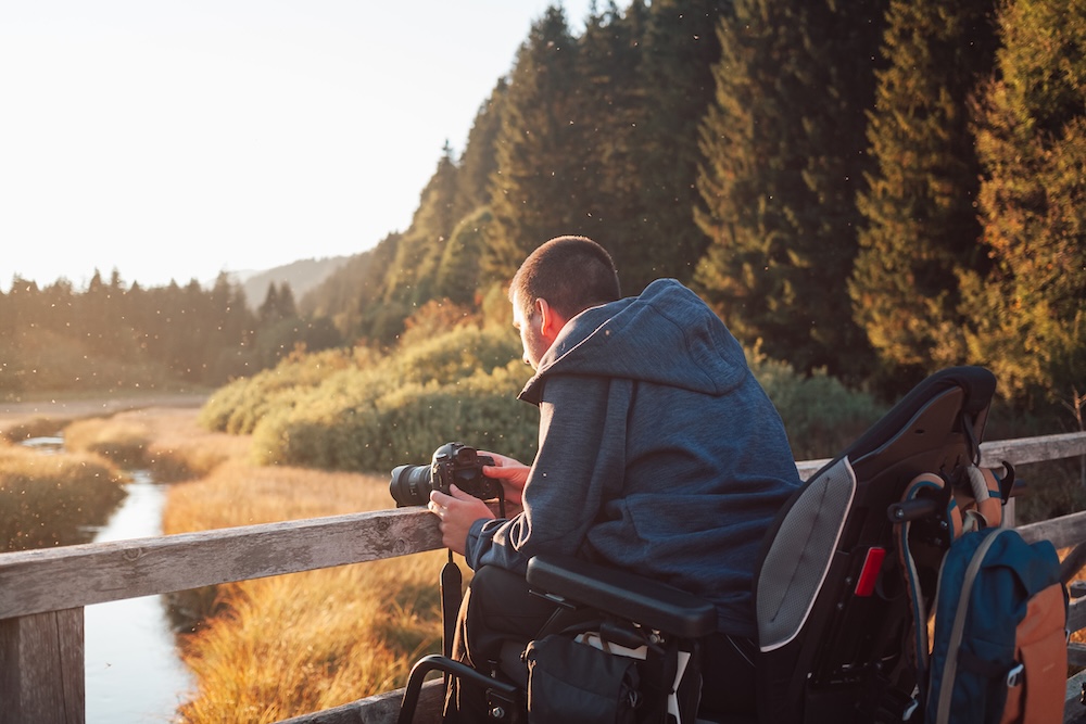 Disabled photographer taking a photo of mountain nature at dusk Tetraplegic veteran completes 79-mile challenge for spinal injury charity