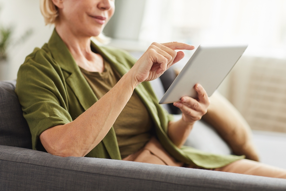 close-up-mature-woman-sitting-sofa-typing-digital-tablet-living-room-home Exemplar to bring YetiCare interactive tablets to its homes