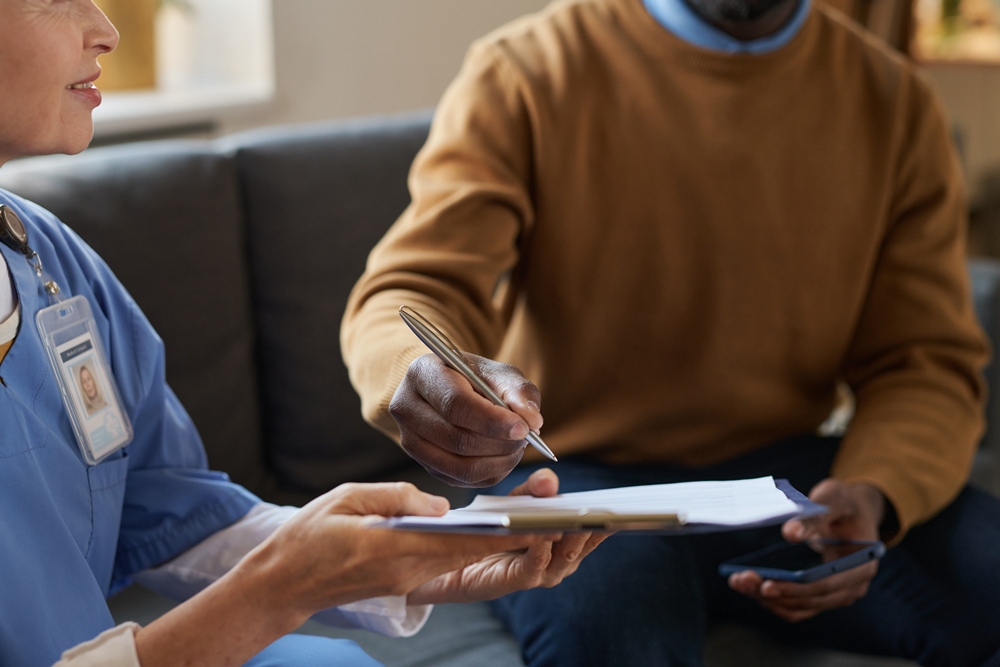 closeup-black-man-signing-agreement-medical-services Report calls for national service to tackle adult social care postcode lottery